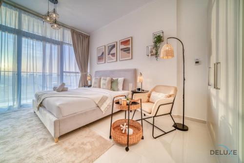 a bedroom with a bed and a chair at Picturesque Studio at Carson A DAMAC Hills Dubailand by Deluxe Holiday Homes in Dubai