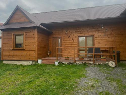 a log cabin with a porch and a deck at Domek wakacyjny -Izbecka in Pieniążkowice