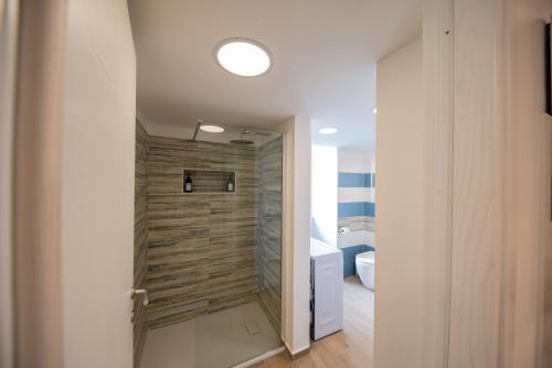 y baño con ducha y pared de madera. en Apulia Home, en Bisceglie