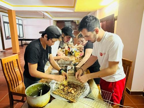 Un groupe de personnes autour d'une table préparant des repas dans l'établissement HAPPY FAMILY HOTEL, à Sa Pa