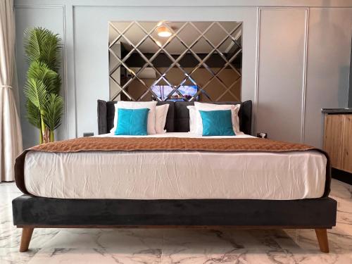 a bedroom with a large bed with blue pillows at Blue Luxury Studio in Mamaia