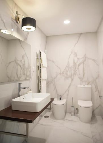 a white bathroom with a sink and a toilet at Espigueiro - Casas de Selim in Arcos de Valdevez