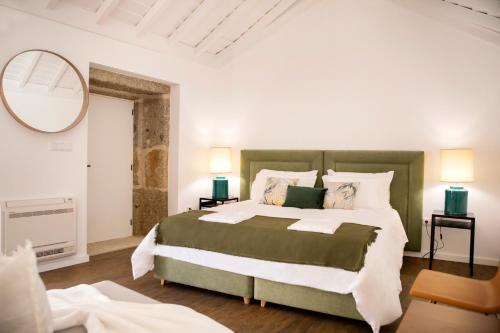 a bedroom with a large bed and a mirror at Espigueiro - Casas de Selim in Arcos de Valdevez