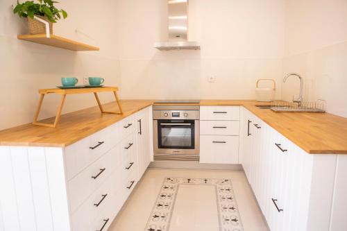 a kitchen with white cabinets and a sink and a stove at Mãe - Casas de Selim in Arcos de Valdevez
