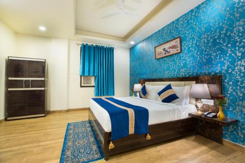 a bedroom with a bed and a blue wall at The Alpino Hotel in New Delhi