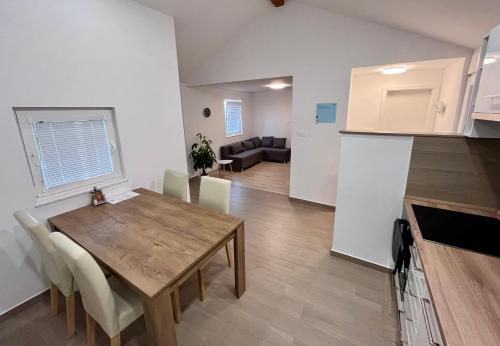 eine Küche und ein Wohnzimmer mit einem Holztisch und einem Esszimmer in der Unterkunft Apartment RIO in Sečovlje