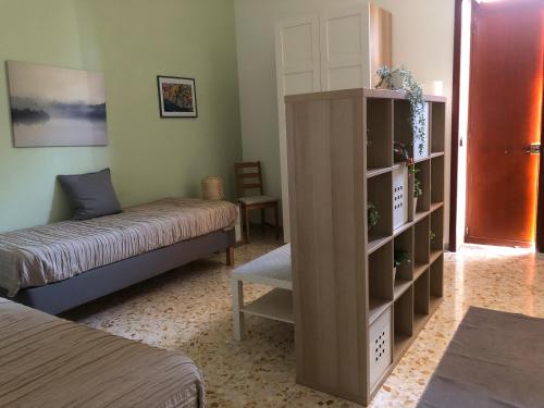 a living room with a bed and a book shelf at BnB Nonna Maria in Poggiomarino