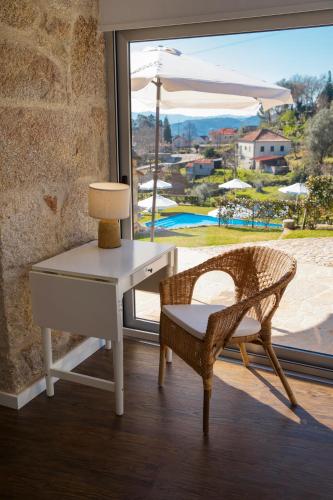 a desk and a chair next to a window at Altiva - Casas de Selim in Arcos de Valdevez