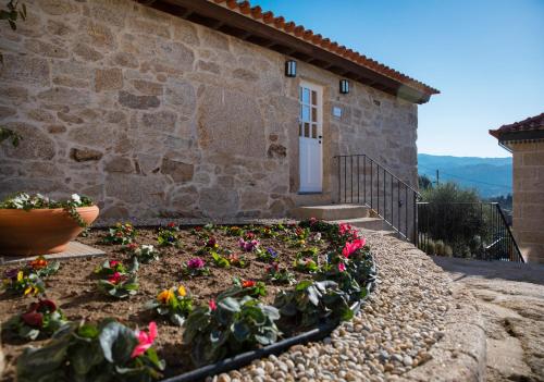 a garden in front of a stone house at Primitiva - Casas de Selim in Arcos de Valdevez