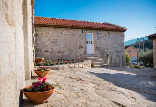 a house with flower pots on the side of it at Primitiva - Casas de Selim in Arcos de Valdevez