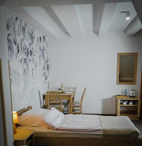 a bedroom with a bed and a table with a television at Willa Centrum in Supraśl