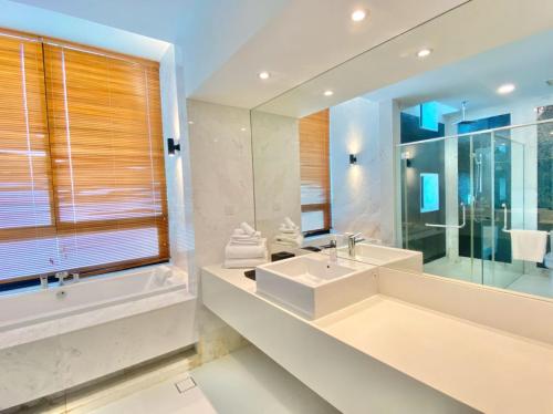 La salle de bains est pourvue d'un lavabo et d'un grand miroir. dans l'établissement Merissa Luxury Private Pool Villa, à Pantai Cenang