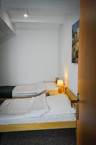 two beds in a room with a door open at Willa Centrum in Supraśl