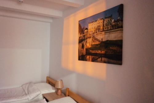 a bedroom with a painting hanging on the wall at Willa Centrum in Supraśl