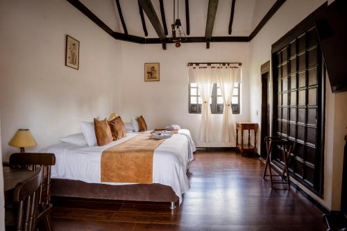 een slaapkamer met 2 bedden en een raam bij Hotel Hacienda El Salitre in Paipa