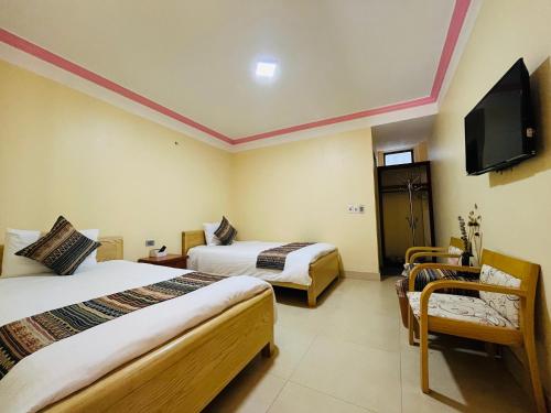 a hotel room with two beds and a flat screen tv at HAPPY FAMILY HOTEL in Sa Pa