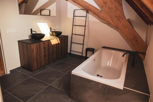 La salle de bains mansardée est pourvue d'une baignoire. dans l'établissement Sint-Jacobshoeve 3, à Audenarde