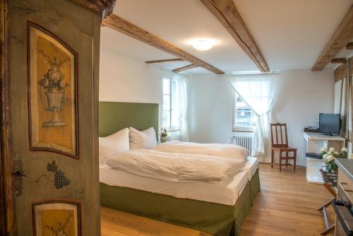 een slaapkamer met een bed in een kamer bij 3 Sterne Boutique Gasthaus Pöstli in Rifferswil