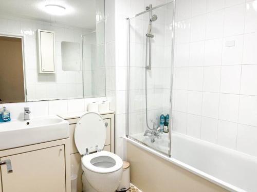 La salle de bains est pourvue de toilettes, d'un lavabo et d'une douche. dans l'établissement Lovely 2 bedroom flat with free parking, great transport links to Central London, the Excel Centre, Canary Wharf and the O2!, à Londres