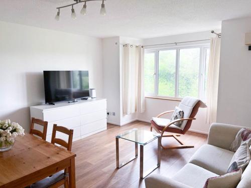 a living room with a couch and a table at Lovely 2 bedroom flat with free parking, great transport links to Central London, the Excel Centre, Canary Wharf and the O2! in London