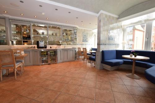 a restaurant with a blue couch and tables and chairs at Hotel Wiking Sylt in Westerland (Sylt)