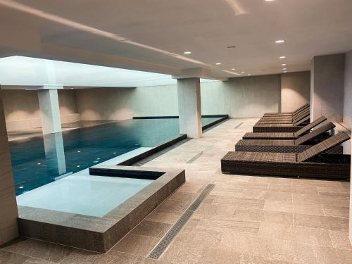a swimming pool in a building with stairs and water at Kazalnica Family&Conference Resort in Karpacz
