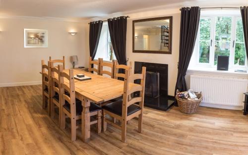 a dining room with a table and chairs and a fireplace at Auchendennan Farm Self Catering Cottages in Balloch