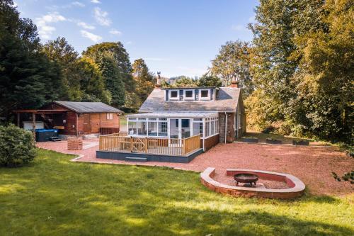 a house with a large yard with a fire pit at Auchendennan Farm Self Catering Cottages in Balloch