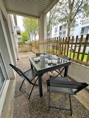 une table et deux chaises assises sur une terrasse dans l'établissement Le Khoros - Proche plage, à La Rochelle