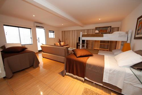 a bedroom with two bunk beds and a desk at Iguassu Flats Hotel in Foz do Iguaçu