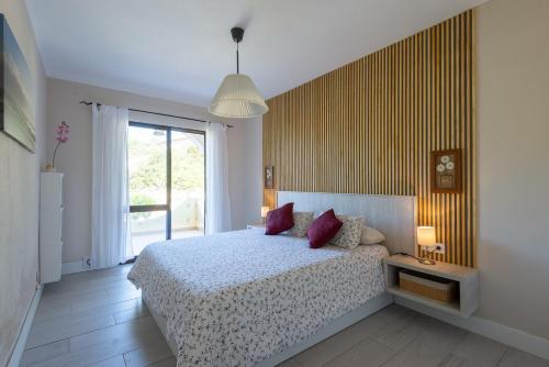 een slaapkamer met een bed en een groot raam bij Apartment Colina Sol in Carvoeiro