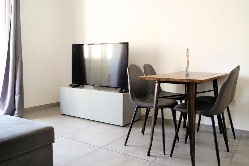 - une salle à manger avec une table, des chaises et une télévision dans l'établissement Modern Apartments Close to the Sea, à Il-Gżira