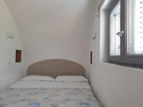 małe łóżko w białym pokoju z oknem w obiekcie SWEET HOME LA CHICCA w mieście Ischia