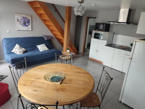 a living room with a table and a blue couch at Claude et Astrid in Tour-en-Bessin