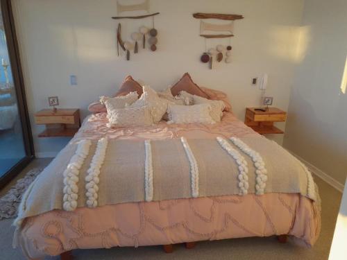 a bedroom with a bed with a pink and gray comforter at Espectacular departamento de Lujo, al frente del mar in Coquimbo