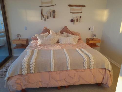 - une chambre avec un lit et une couette rose et gris dans l'établissement Espectacular departamento de Lujo, al frente del mar, à Coquimbo