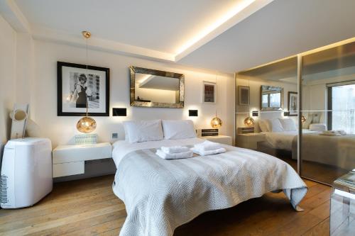 a bedroom with a large bed and a mirror at Stunning 3 bedroom, 3 bathroom duplex with terrace in London