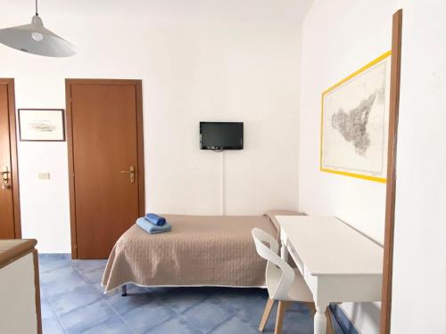 a bedroom with a bed and a desk and a television at Rosa Dei Venti Marettimo in Marettimo