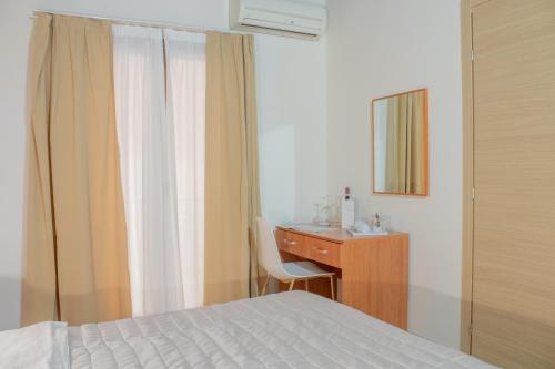 a bedroom with a bed and a desk and a mirror at Porta delle Botteghelle in Trapani