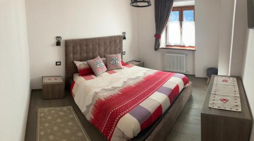 a bedroom with a large bed and a window at Dolomites Holiday Home in Canazei