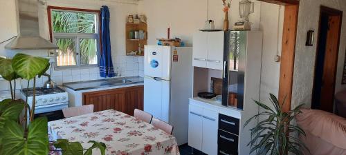 uma cozinha com uma mesa e um frigorífico branco em Marazul em Aguas Dulces