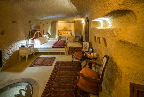ein Schlafzimmer mit einem Bett und einem Tisch in der Unterkunft Maya Cave in Uchisar