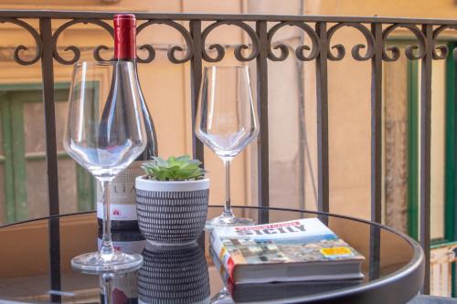 a table with two wine glasses and a book at Porta delle Botteghelle in Trapani