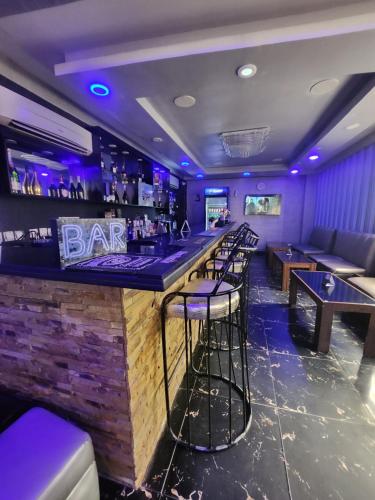 a bar with purple lighting and bar stools at Atlantic Palms Suites in Lekki