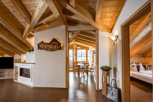 a living room with wooden ceilings and a fireplace at Ferienwohnungen Reich in Schönau am Königssee