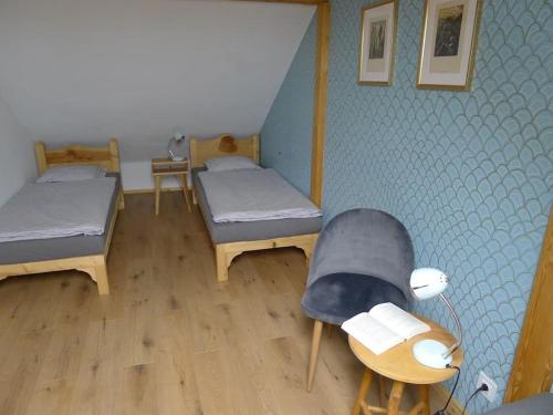 a room with two beds and a chair and a table at Apartmán Bellevue - Český ráj in Všeň