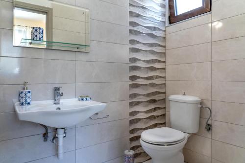 un baño con inodoro y lavabo en Villa Rafaella2, en Koskinou