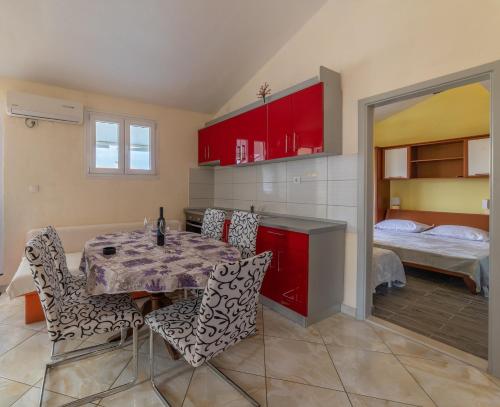 a kitchen with a table and chairs and a bedroom at Apartments Ribarević in Makarska