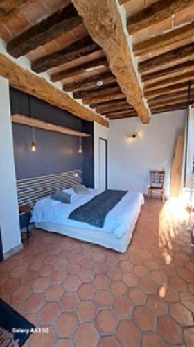 - une chambre avec un grand lit dans un bâtiment dans l'établissement L'ALCOVE HOTEL RESTAURANT, à Villematier