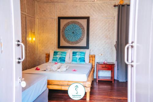 a bedroom with two beds with blue pillows at AQUARIUM Gili Air in Gili Air